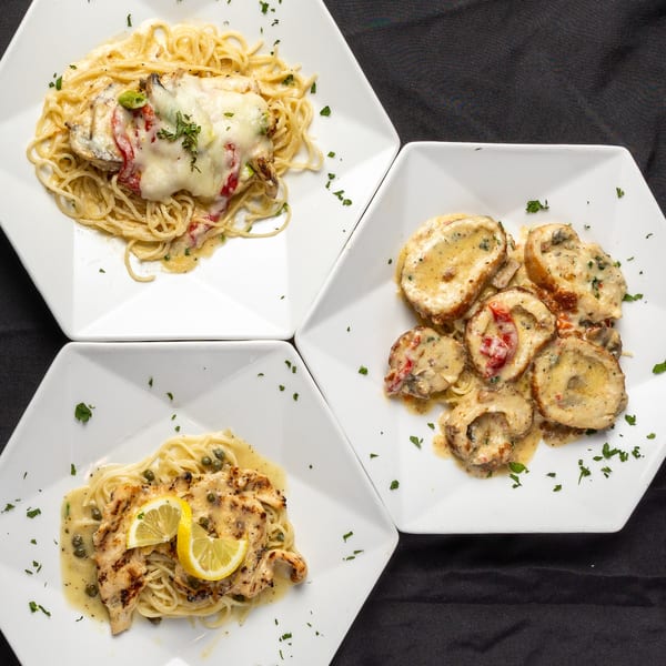 Three Italian pasta dishes, including chicken parmesan, chicken scaloppini, and chicken piccata, on white plates.
